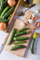 Fresh green zucchini on wooden board with knife. Top view.