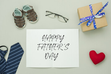Table top view Happy Fathers day holiday background concept. Flat lay of greeting card of season. Arrangement object gift box brown shoes red heart necktie eyeglasses on grey background.