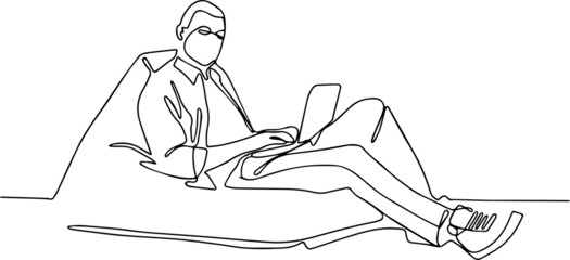 Young man using laptop on sofa at home. freelancer, blogger or a student listens to the audio lesson, book or music. social distance. stay home. epidemic and quarantine