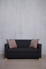 Sofa with copy space over concrete wall