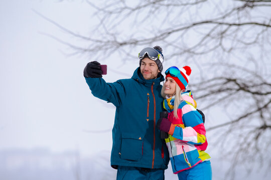 Smiling  Caucasian Couple Taking Selfie Pictures During Tube Activities In Winter Time