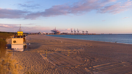 Baltic Sea and the Stogi beach in sunrise colors with DCT terminal, Gdansk. Poland. - obrazy, fototapety, plakaty