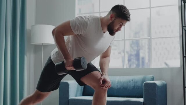 Concentrated sportsman with beard practices bent-over rows