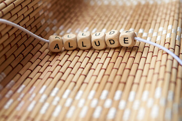 Word allude lined with wooden cubes