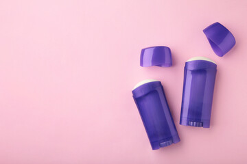 Violet antiperspirant deodorant on pink background. Skin care concept. copy space, top view