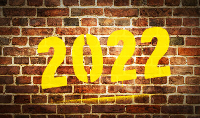 Fototapeta na wymiar 2022 year sign spray painted on the brick wall