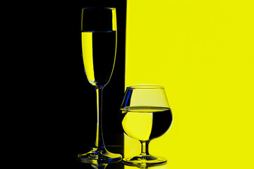 Glassware Ideas. Two Different Glass Cups in One Line With Vivid  Black And Yellow Colorful Background.