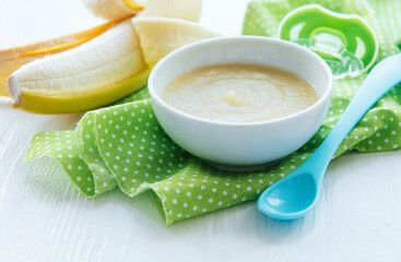 Bowl with fruit baby food and banana