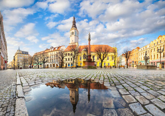 Swidnica, Poland. Panorama of Market Square (Rynek) with building of historic Town Hall reflecting in puddle