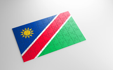 Fototapeta na wymiar A jigsaw puzzle with a print of the flag of Namibia, pieces of the puzzle isolated on white background. Fulfillment and perfection concept. Symbol of national integrity. 3D illustration.