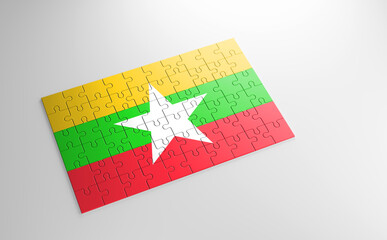 A jigsaw puzzle with a print of the flag of Myanmar, pieces of the puzzle isolated on white background. Fulfillment and perfection concept. Symbol of national integrity. 3D illustration.