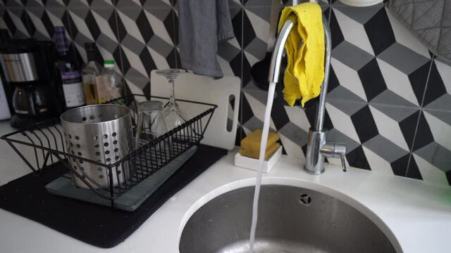 Tap Water From Faucet Left Open Flowing In Kitchen Sink - Concept Of Water Wastage - Static Shot