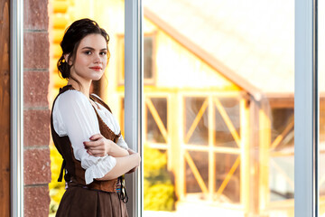 Lovely Tranquil Caucasian Woman in Old Medieval Dress in Front of Large Glass Window