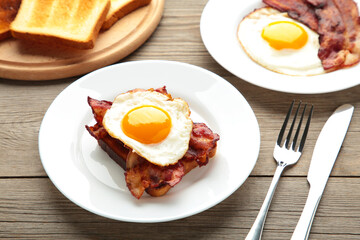 Traditional full English breakfast - fried eggs, beans, bacon and toast on grey background with copy space for text.
