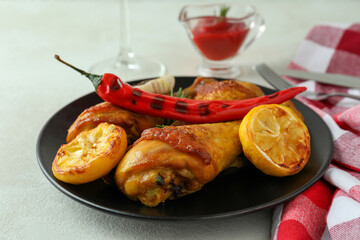 Concept of delicious eating with roast chicken drumsticks on white textured table