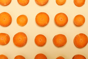 Slices of fresh carrot on beige background