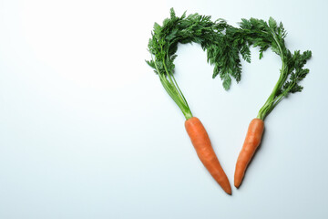Heart shape made of carrots on white background
