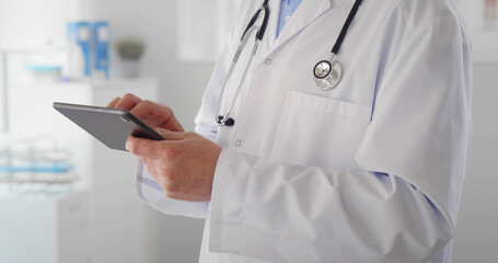 Cropped shot of man doctor checking data on digital tablet