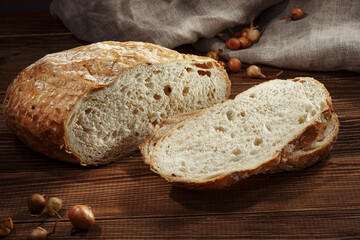 Sliced onion bread on a linen and wooden background