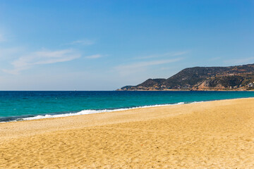 Obraz premium Beach with blue sea and hills.