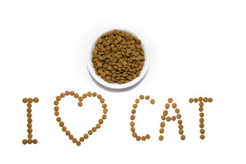 Dry food for cats and dogs in a white bowl. Heart from the food. Inscription I love cats. Studio white background.