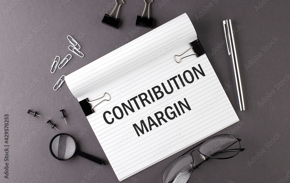 Poster text contribution margin on notebook and office tools on gray desktop