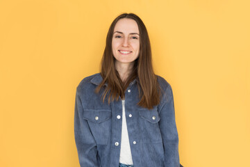 Young girl smiling on yellow background