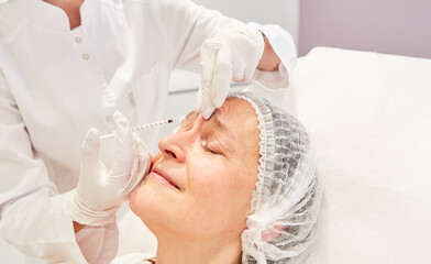 Obraz na płótnie Canvas Forehead wrinkles are injected with hyaluronic acid
