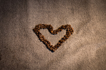 heart arranged from delicious black coffee on a soft background in the middle of the photo