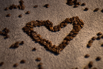 heart arranged from delicious black coffee on a soft background in the middle of the photo. Surrounded by spilled coffee