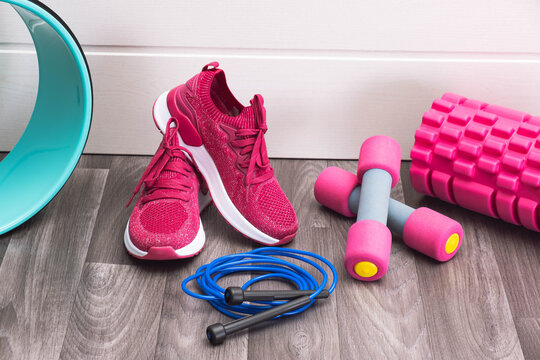 home sports - pink sneakers, dumbbells, jump rope lie on the floor
