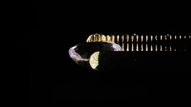 natural morganite gemstone in tweezer on the turn table