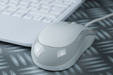 grau-weiße Computer-Maus (mouse) neben einem Netbook / Notebook / Laptop