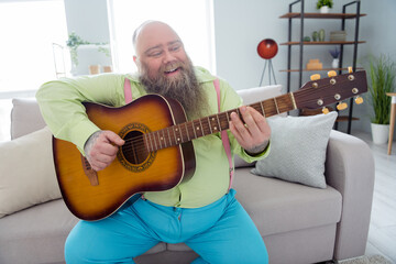 Photo of sweet handsome big belly man wear green shirt singing playing guitar music indoors house room