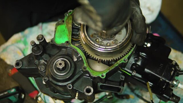 a man restores his motorcycle in the garage