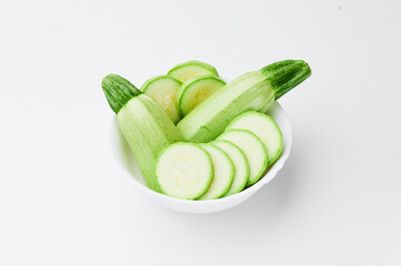 Raw sliced zucchini in a white plate on a white background. Mockup. Photo for clipping. 