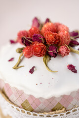 Easter cake on a pink background decorated with dried flowers