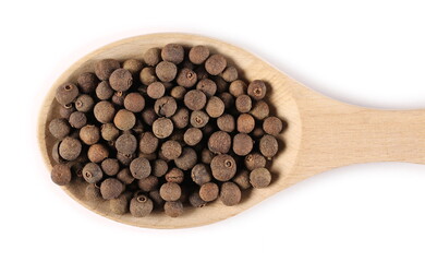Allspice, pimento spice, Jamaican pepper pile in wooden spoon isolated on white background, top view