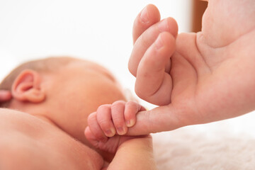 Italy, April 2021. The hand of a very small child holds the hand of the mother