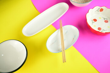 cute ceramic bowl white plate on bright pink and yellow background 
beautiful top view