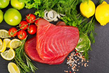Tuna raw Steak, tuna sashimi, tuna fish sliced with vegetables. Healthy eating with seafood, we cook at home. Cooking receipt concept, fish menu, fish meat layout on black stone