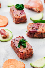 Composition with raw square cutlets on light background. Natural food for dogs. BARF dog diet. Close up