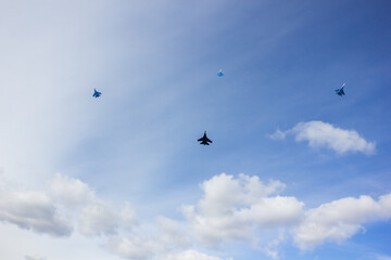 four jet planes are flying in a tight formation. dangerous aerobatics are shown at the aviation festival by pilots. military parade of modern fighter planes
