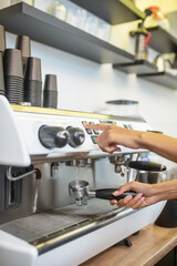Female hands near the coffee machine