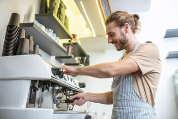 Knowledgeable man cleaning filter of coffee machine