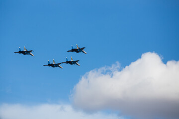 military aircraft fly at low altitude over the audience during the air show. patriotic military holiday. demonstration performance of professional pilots at the airshow