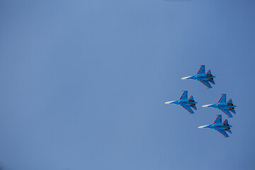 military aircraft fly at low altitude over the audience during the air show. patriotic military holiday. demonstration performance of professional pilots at the airshow
