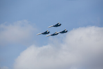 military aircraft fly at low altitude over the audience during the air show. patriotic military holiday. demonstration performance of professional pilots at the airshow