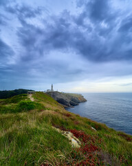 beautiful green landscape with dramatic blue sky, near the Santander lighthouse in Cantabria, Spain