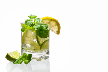 Citrus lemonade with ice in a glass decorated with lemon, lime and mint slices and on a white background. Fresh summer drink. Detox. Healthy food rich in vitamins and antioxidants. Copy space